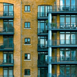 Fenêtres et balcons d’un immeuble dans un cadrage panoramique très étroit.
